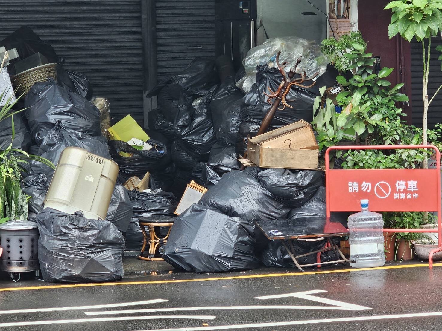 豐原王姓一家五口命案,這家人租屋處連日被整理後,豐原清潔隊派車協助喪宅垃圾服務清理,暫時堆置門口的廢棄物中有使用已久的家具和電氣品。記者游振昇/攝影