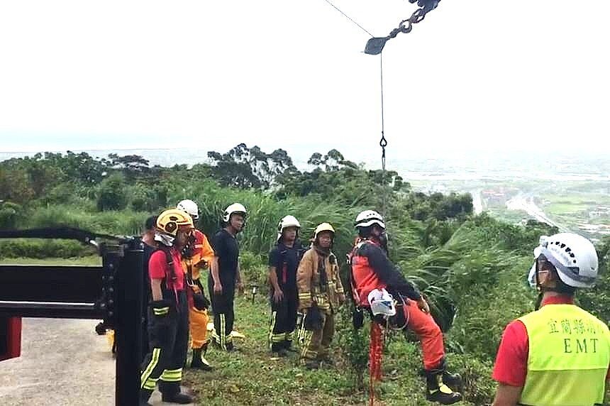 北宜公路13日發生賓士車墜落深約80米邊坡,人卡在車內受困,警消獲報到場繩索垂掛救人。圖/民眾提供