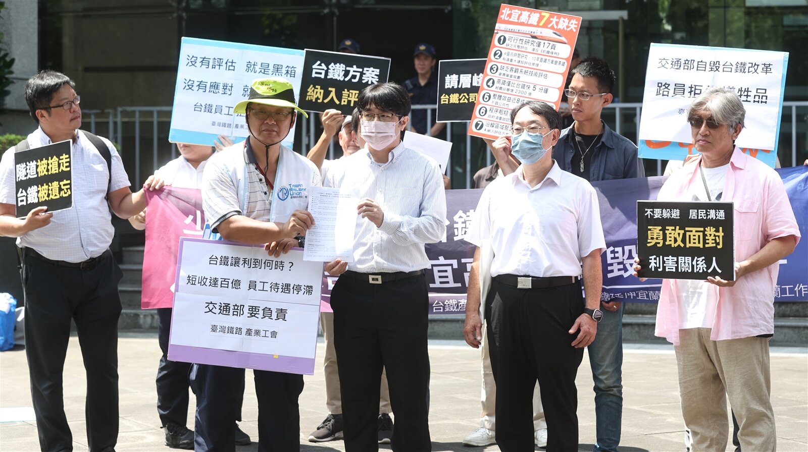 台鐵產業工會上午在交通部外頂著烈陽舉行「少百億收入,斷台鐵未來!交通部推北宜高鐵,自毀台鐵改革」記者會,要求即刻停止高鐵延伸宜蘭案環評程序,且拒絕黑箱讓利,隨後由交通部代表(前排右一、二)接受陳情書。記者侯永全/攝影