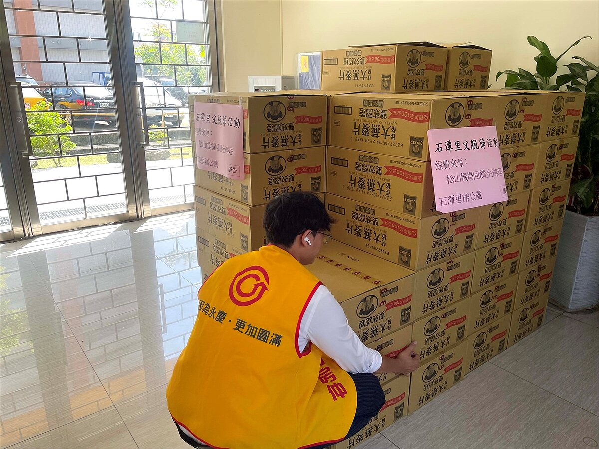 台北市內湖區石潭里辦公室準備一罐燕麥粉送給里民，永慶房屋人員協助里長搬運、發送。