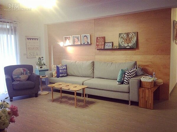 
3.客廳擺設藍色布沙發，茶几很有特色，牆上則掛著蔡逸帆的油畫作品。