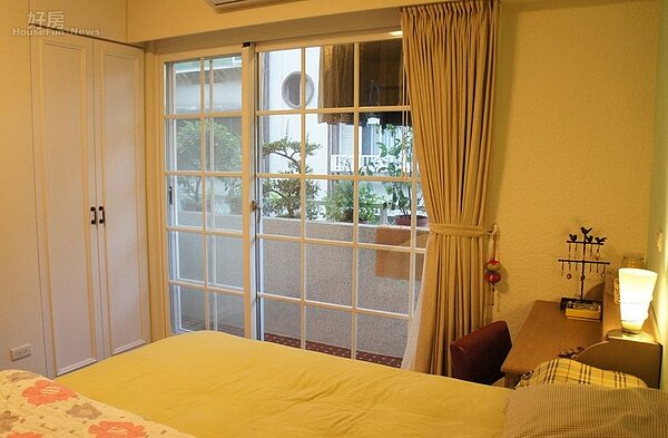 8.主臥房陽台採用格子鋁門窗,無論視野或採光都很棒,擺滿盆栽的陽台也很有鄉村風。
