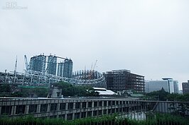 站在誠品松菸店三樓，可遠眺正在施工中的大巨蛋。因誠品的進駐與大巨蛋的興建，讓周邊房價衝上更高一波。(好房記者張聖奕/攝影)