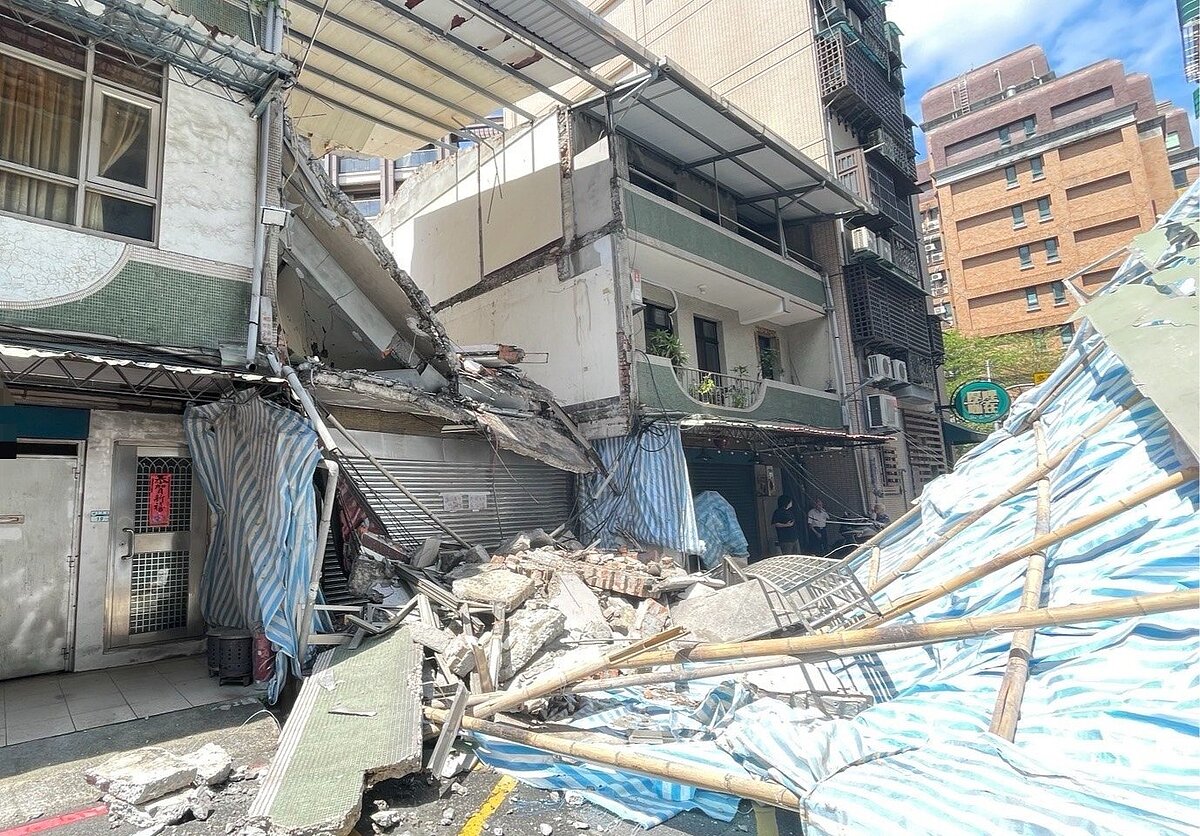 正在進行拆除工程的透天厝樓地板崩塌，土石壓毀鷹架波及鄰宅及電纜線。圖／記者黃子騰翻攝
