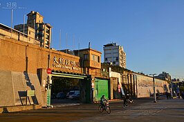 大稻埕碼頭已不再是貿易港口，單車客與散步的民眾取代了過去進出的貨物，但留有＂大稻埕碼頭＂五個大字的閘門，卻讓人彷彿看見昔日風華。（圖文／好房News記者 陳韋帆）