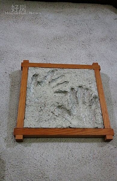 
5.羅約翰與吳連春在第一棟報紙厝完工的紙屋前，留下各自的手印做紀念。