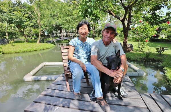 農莊主人羅約翰與太太吳連春力行環保，身旁是他們飼養的小黑狗。