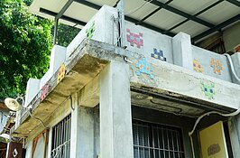 抬頭一看，二樓圍牆上所設計的裝置藝術，就是八位元電玩時期最風彌大眾的「小蜜蜂」電動玩具中的小蜜蜂。