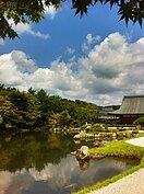 寺中曹源池池水倒映著嵐山天空中的白雲藍天，彷彿像是一幅畫。