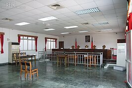審判庭內重現當年的情境，如今雖然空空蕩蕩，卻也難以抹滅這段傷心過往。