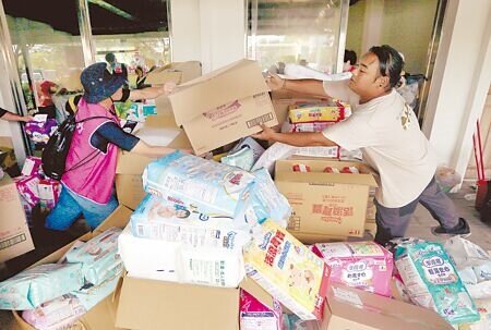 
馬太鞍溪堰塞湖溢流重創光復市區，許多志工紛紛前往災區支援，一群志工26日在物資站中忙著整理各式生活用品。（范揚光攝）
