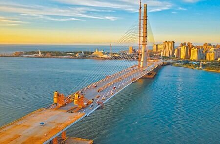 淡江大橋9月16日舉行合龍典禮,從新北市八里端遠望淡江大橋,橘紅色晚霞映照出合龍後的大橋新風貌。(本報資料照片)