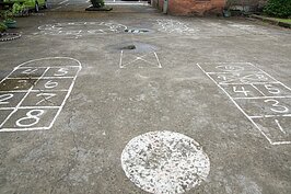 屋前廣場地上畫著各種各樣「跳格子」遊戲的圖案。在電動玩具與網路遊戲發達的現在，大概只有六年級以前的熟男熟女們知道怎麼玩。