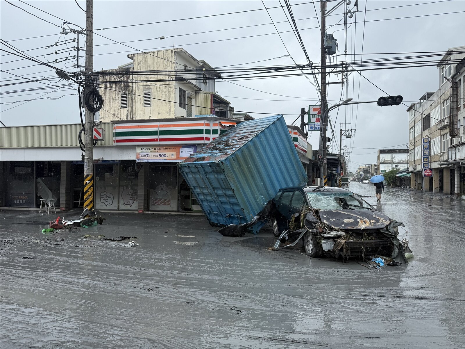 甚至還有大型貨櫃被洪水推翻,壓毀停放車輛。記者張策/攝影