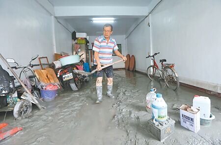 花蓮萬榮鄉馬太鞍溪堰塞湖23日溢流,滾滾泥水淹進光復市區,24日積水退去一位民眾設法清理家中厚厚的淤泥。(范揚光攝)