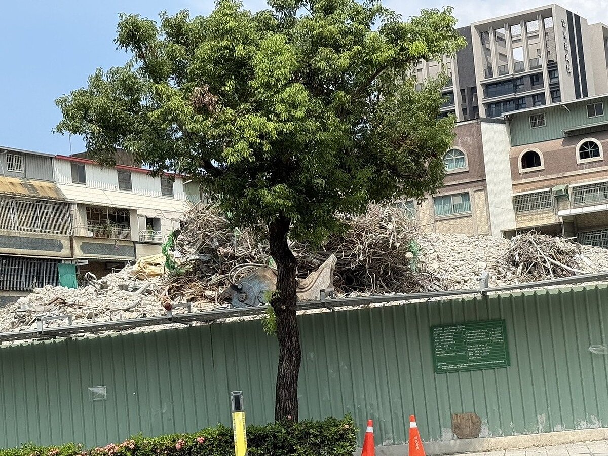 高雄市明誠一路一處建築工地廢棄鋼筋和土石堆了約2層樓高,高度已超過圍籬,和行道樹齊高。圖/聯合報記者石秀華攝影