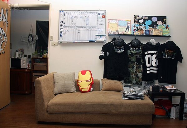 5.簡單的沙發後方有著行事曆,一旁還有著嘻哈的服裝行頭。