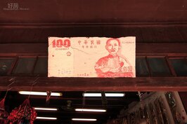 手繪的百元大鈔高高掛在門楣上。