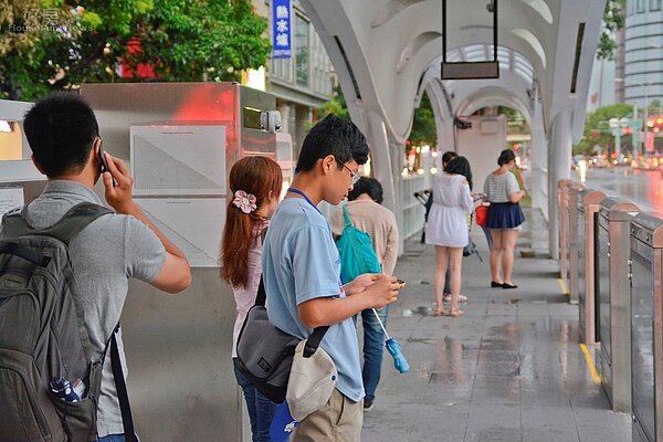 說好的五分鐘一班呢?民眾苦等十多分鐘,開始紛紛玩起手機雨打電話跟家人報備BRT延遲了,所以會晚點回到家。(好房News記者 陳韋帆/攝影)