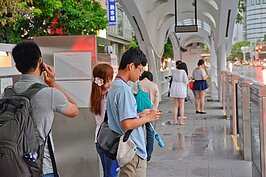 BRT車站其實就像台北捷運站一般，民眾低頭划手機等車。