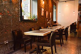 斑駁的紅磚牆面與整齊的桌椅融為一體，一點也不雜亂。