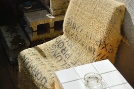 用裝咖啡豆的麻布袋做為椅套十分有味道，小桌子則以裝潢時的剩料拼湊而成，不僅省了材料費更與店內裝潢融為一體。