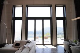 超大落地窗，將光線引入到客廳中。大型格狀映照著山景，如同中國傳統建築「借景」的設計技法。
