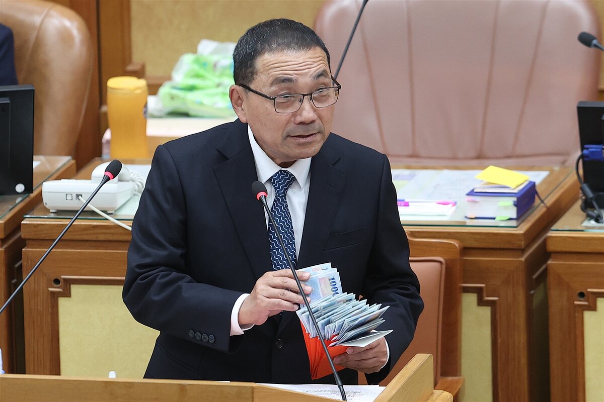 今天為新北議會市政總質詢第一天，新北市長侯友宜出席備詢，普發現金一萬即將發放，新北市議員廖宜琨送上玩具鈔並呼籲新北市加碼。記者葉信菉／攝影 