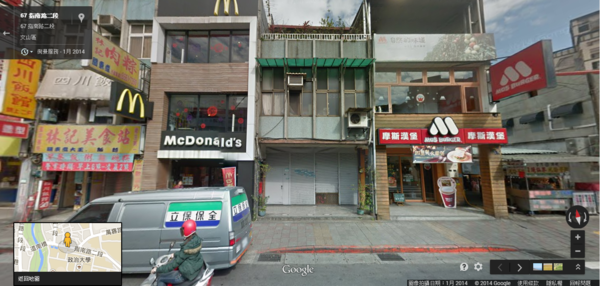 指南路二段上一棟夾在麥當勞和摩斯漢堡中間的老公寓。（翻攝自Google Map）
