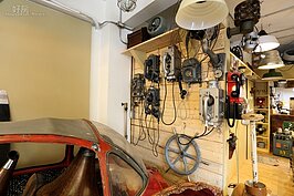 牆上各式各樣的電話等待有緣人青睞。紅色的小型車正等著新零件，進行Car SOS。