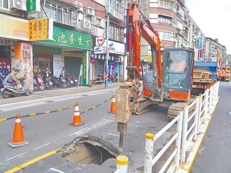 新北市新莊復興路一段道路地下排水箱涵因年久鏽蝕塌陷破大洞,現場廠商機具進場施工開挖作修復工程。(吳嘉億攝)