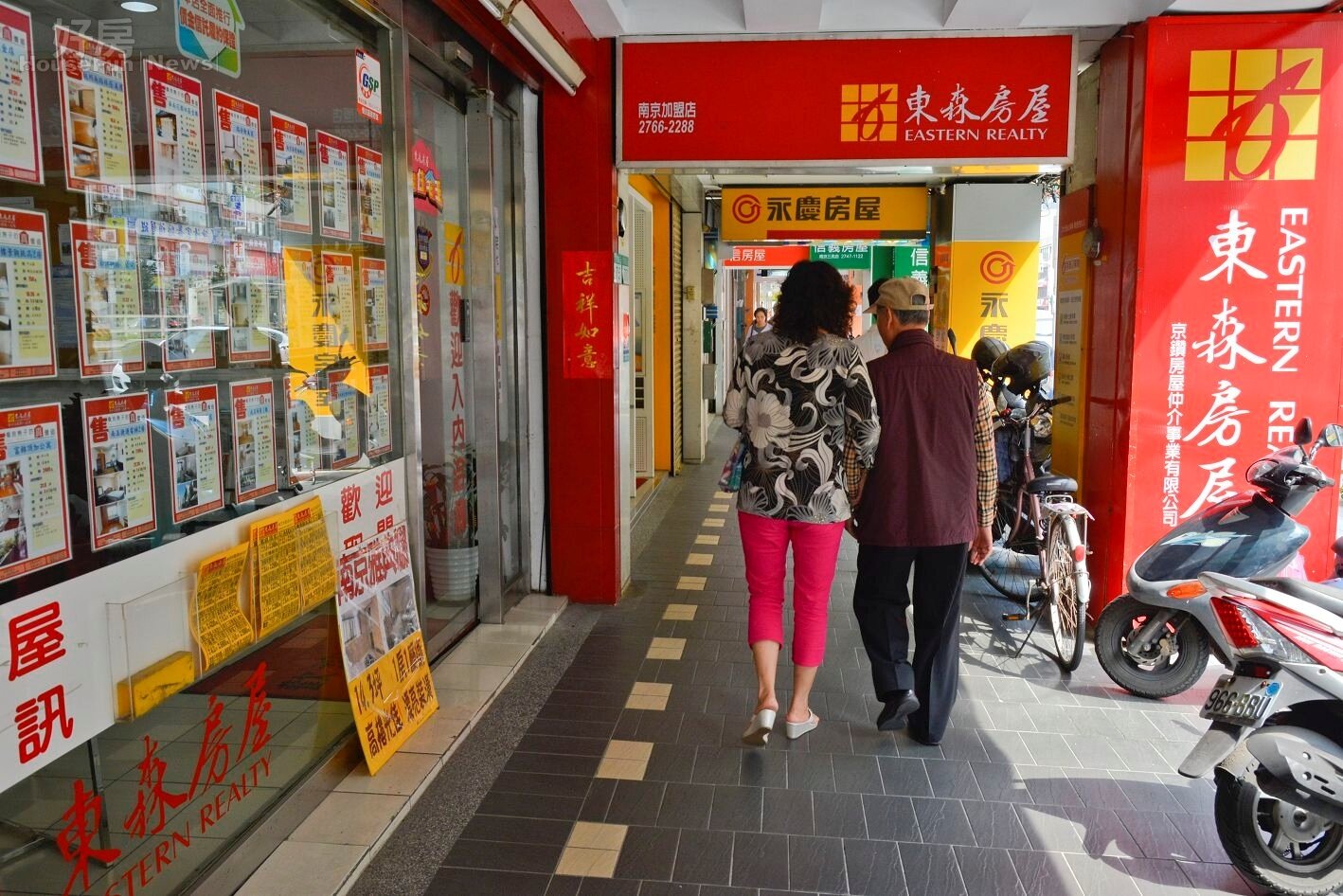 房仲店面,經過的人交頭接耳,討論房價太高情境圖。(好房網News記者 陳韋帆/攝影)