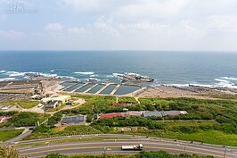 在水泥所圍起來養殖池前方類似迷你台灣的島礁就是台灣最東邊。