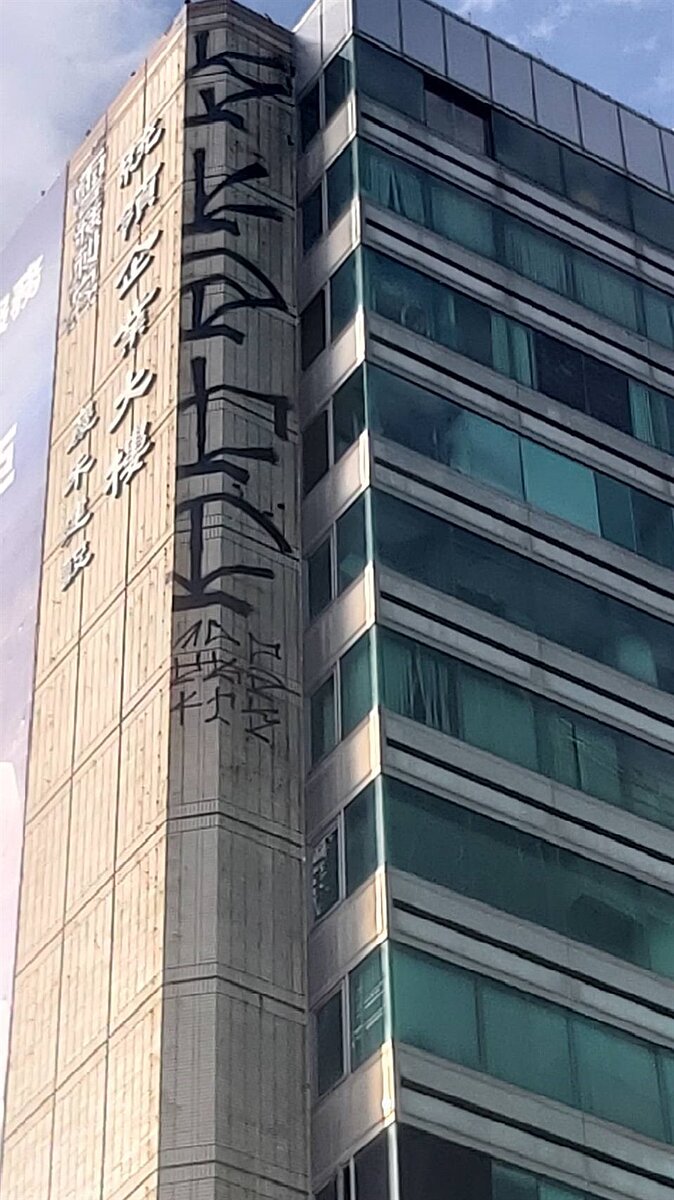 台中市北區中清路一段的大樓高樓層處,出現大規模塗鴉文字,引發市民議論,大樓管委會已提出毀損告訴。記者陳宏睿/翻攝