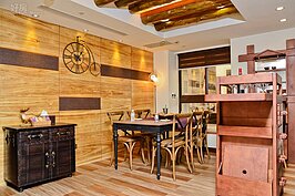 吧台區隔了客廳和餐廳的空間，餐廳的牆面是以常見的梧桐木做為視覺焦點，雖然梧桐木容易發霉受潮，不過經過表面炭烤處理，可以保有原色，又能讓紋理變得明顯，更有自己的表情，同時解決了發霉受潮的疑慮。