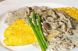 一大片昂貴的松露佈滿在滑嫩爽口的歐姆蛋上。