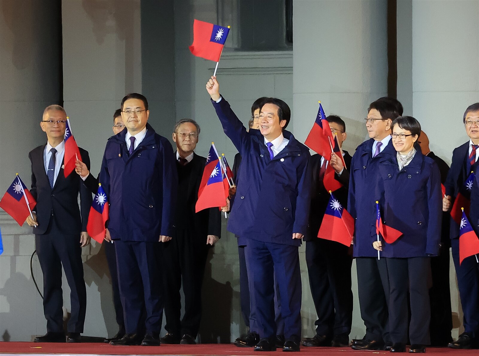 中華民國115年元旦總統府升旗典禮今天舉行，賴清德總統（中）率副總統蕭美琴（右一）等人揮舞國旗致意，稍後賴總統也發表新年談話。記者余承翰／攝影 