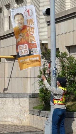 新竹市環保局今天出動30多名清潔隊員，拆除違規廣告旗幟，強調「環保無假期」。