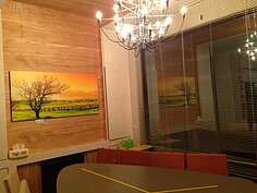 餐廳落地窗設計，可以看到戶外田野風光，牆上畫作和水晶燈，營造出華麗而優雅的氣息。