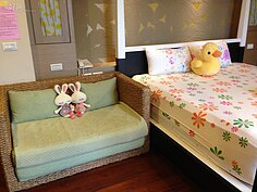 雙人床旁擺放藤椅，取代沙發，更有南洋風。