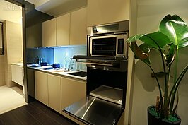 小夫妻兩人在現代社會中大都是外食為主，因此下廚開伙煮飯的機會不多，在廚房洗手槽旁邊可設計幾個格位，放烤箱、烤麵包機、微波爐與熱水瓶會更為方便。綠色植物處則可放置冰箱。