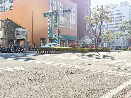 
高雄新興區中正四路、中山一路口的機車停等區內，出現拳頭大小的坑洞，且一旁柏油路面呈現不規則狀的裂痕，恐危及用路人安全。（紀爰攝）
