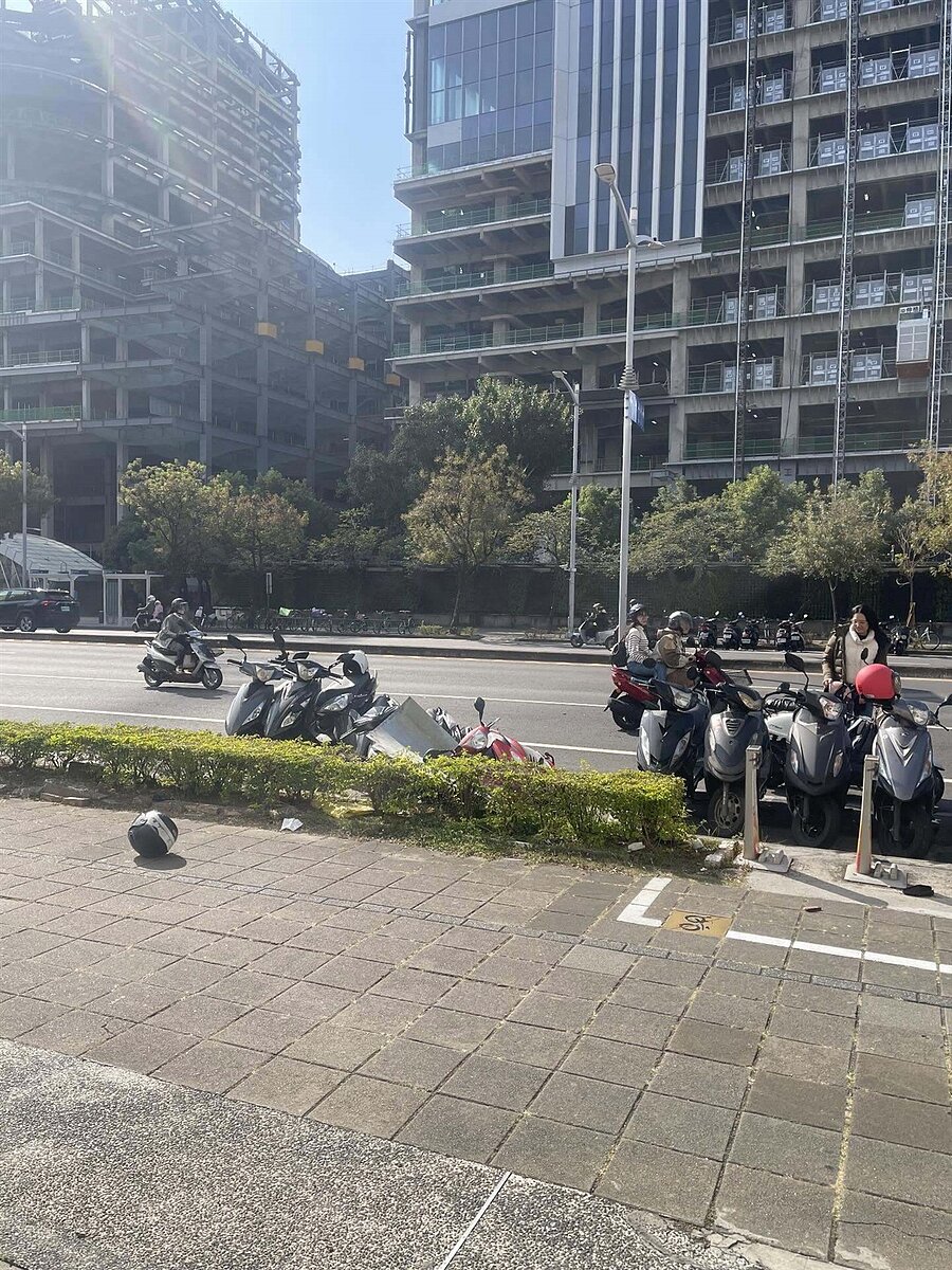 高雄市知名開發建案「富邦凹子底」大樓工地昨日發生意外，工地疑似在假日施工，內部竟飛出一大片金屬板砸中路旁機車，甚至險些砸到路人。圖／記者宋原彰翻攝