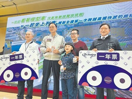 
桃園市學童孫顥（中）參加捷運綠線開箱活動，許下「希望小朋友搭捷運免費」的願望，市長張善政（左二）和桃捷公司董事長沈志藏（左一）12日化身耶誕老公公，送孫家三口1人1張免費1年票。（蔡依珍攝）
