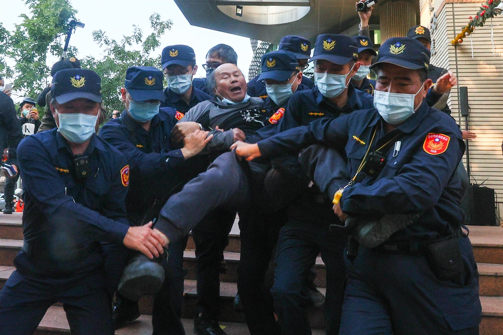 黎明幼兒園園長林金連（中）二○二一年聲援自辦市地重劃抗議行動，遭八名員警抬離現場。本報資料照片 