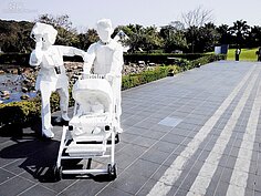 夫妻推著嬰兒車在路上散步，這是街頭常見的景色，但最平常也最溫暖人心。