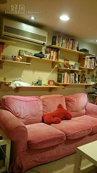 
3.客廳擺放桃紅色沙發，後方層板上有書籍與她到各地採訪買回來的紀念品。