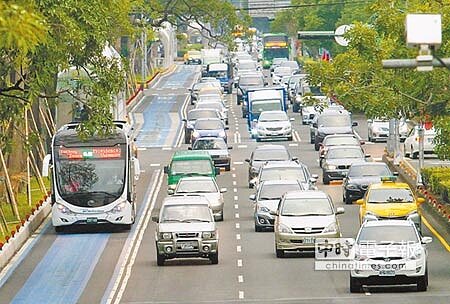 台中市長林佳龍26日視察BRT行控中心,並對於BRT工程進度嚴重落後深表不滿;圖左為下班尖峰時間行駛在專用道上的BRT公車,一旁3線快車道擠滿了其他車輛。(范揚光攝)