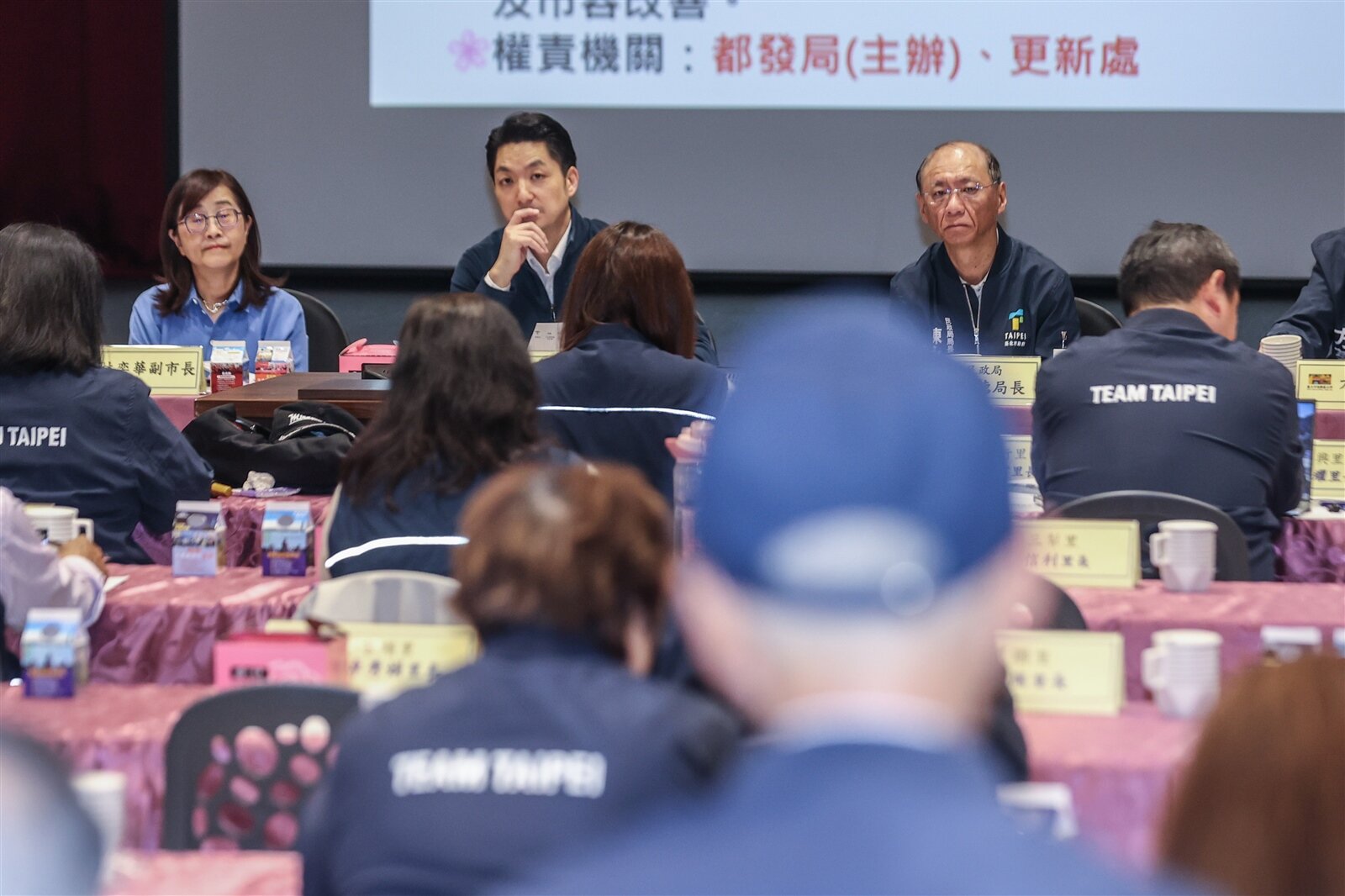 北市長蔣萬安（後排中）昨赴信義區里長座談，大仁里長蔡桂清陳情，指里內有8處基地陸續推動都更改建，民眾迫切需要中繼宅安置。記者曾原信／攝影 