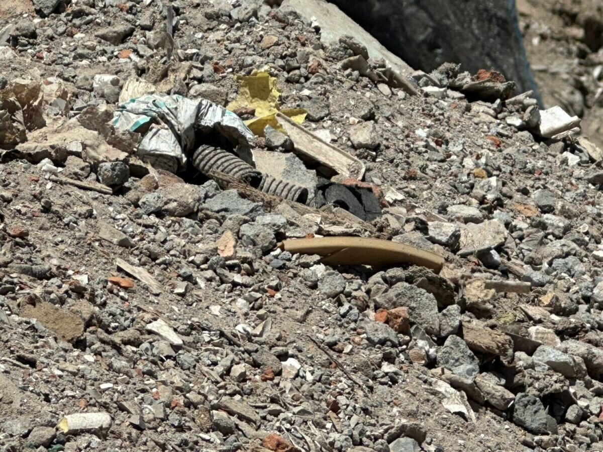 現場廢土堆高度約達5公尺,土石中明顯混雜磚塊、水泥塊、金屬、木材及玻璃等建築拆除殘渣。圖:環保局提供